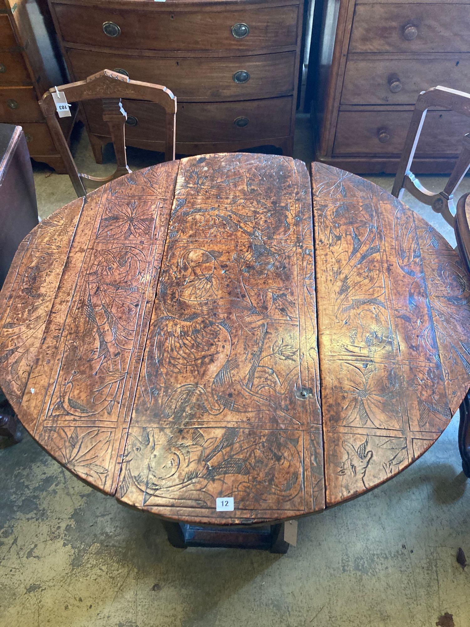 An 18th century carved and stained walnut gateleg table, with oak underframe, width 106cm, 116cm with flaps out, height 74cm